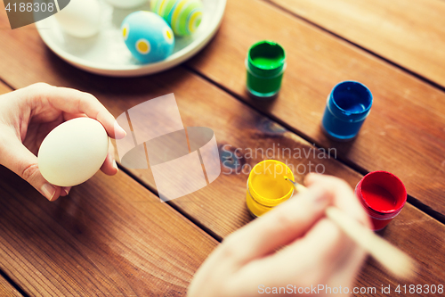 Image of close up of woman hands coloring easter eggs