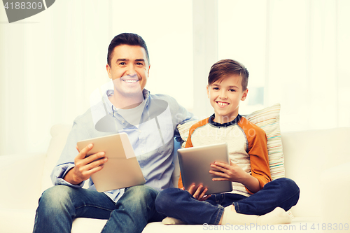 Image of happy father and son with tablet pc at home