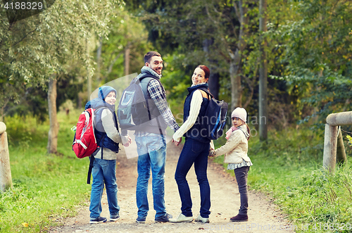 Image of happy family with backpacks hiking walking