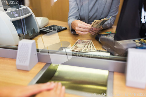 Image of clerk counting cash money at bank office