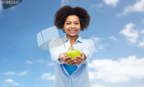 Image of happy african american woman with green apple