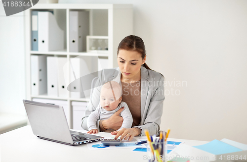 Image of businesswoman with baby working at office