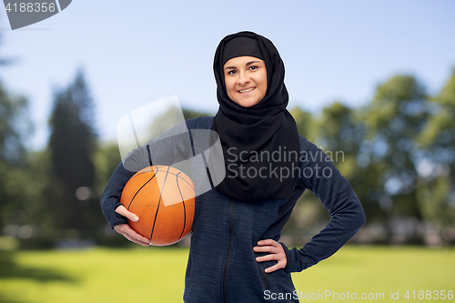 Image of happy muslim woman in hijab with basketball