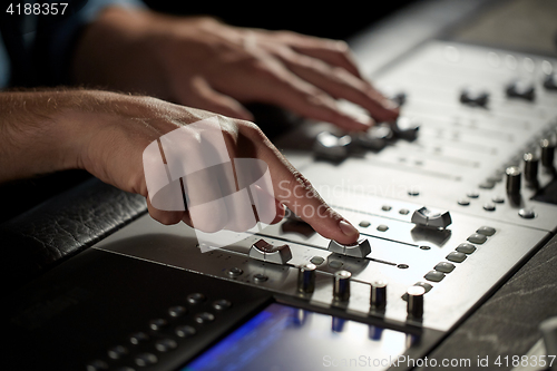 Image of hands on mixing console in music recording studio