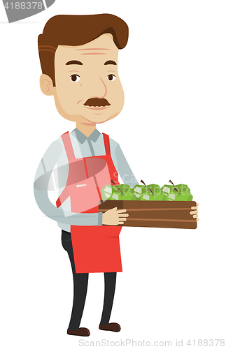 Image of Supermarket worker with box full of apples.