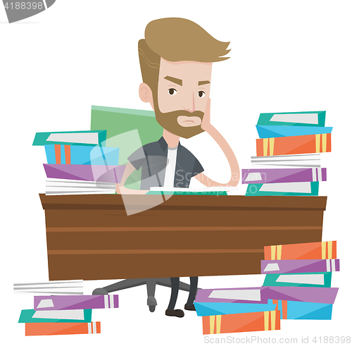 Image of Student sitting at the table with piles of books.