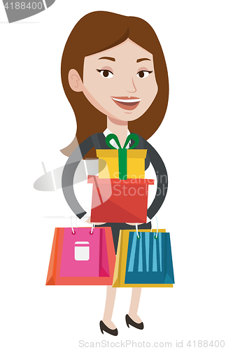 Image of Happy woman holding shopping bags and gift boxes.