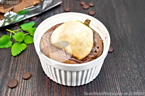 Image of Cake chocolate with pear in white bowl on dark board