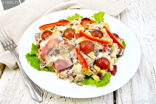 Image of Salad of meat and cheese with grapes on light board