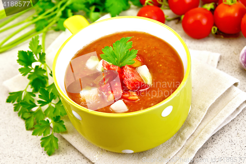 Image of Soup tomato in yellow bowl on napkin