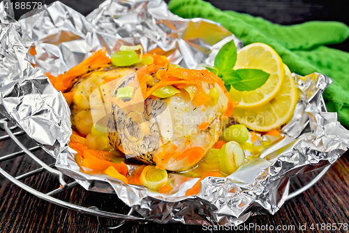 Image of Pike with carrots and lemon in foil on board