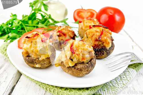 Image of Champignons stuffed with meat and peppers in plate on napkin