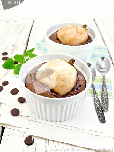 Image of Cake chocolate with pear in white bowl on kitchen towel