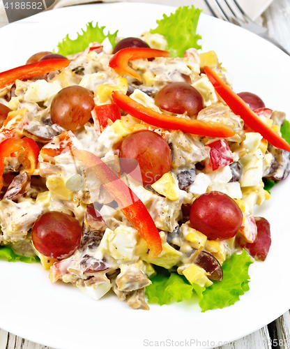 Image of Salad of meat and grapes on light board