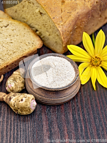 Image of Flour of Jerusalem artichoke in clay bowl with bread on board