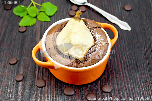 Image of Cake with chocolate and pear in red bowl on board