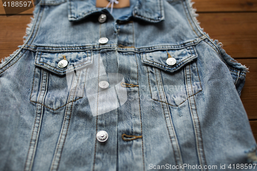 Image of close up of denim vest or waistcoat on wood