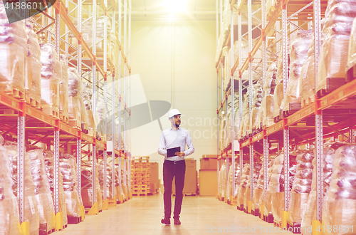 Image of happy businessman with clipboard at warehouse