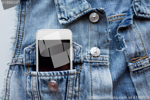 Image of smartphone in pocket of denim jacket or waistcoat