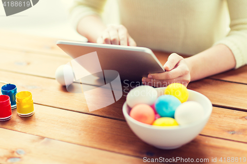 Image of close up of woman with tablet pc and easter eggs