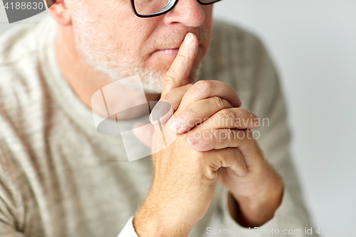 Image of close up of senior man in glasses thinking