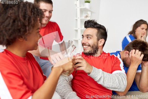 Image of happy football fans or friends with beer at home