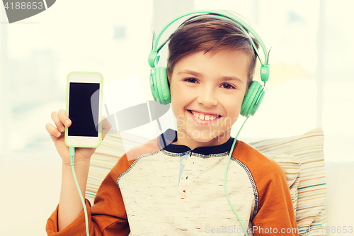 Image of happy boy with smartphone and headphones at home