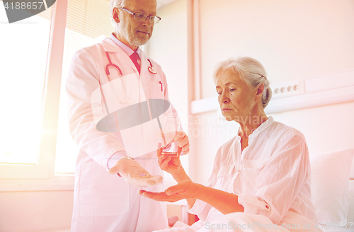 Image of doctor giving medicine to senior woman at hospital