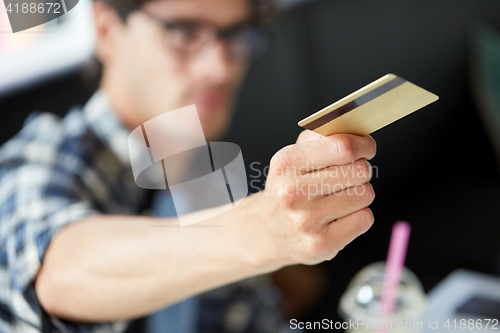 Image of man paying with credit card at cafe