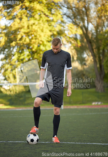 Image of soccer player playing with ball on football field