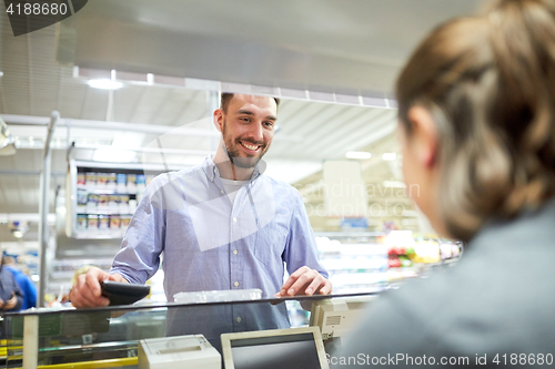 Image of happy man with wallet at store cash register