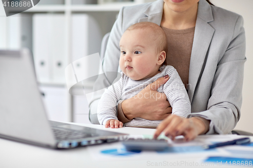 Image of businesswoman with baby working at office