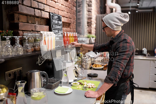 Image of man or barman cooking smoothie at vegan cafe