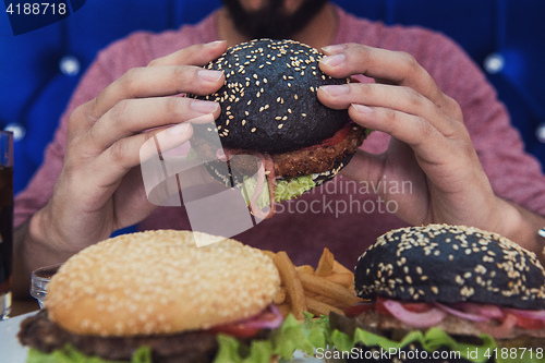 Image of Man eating burgers