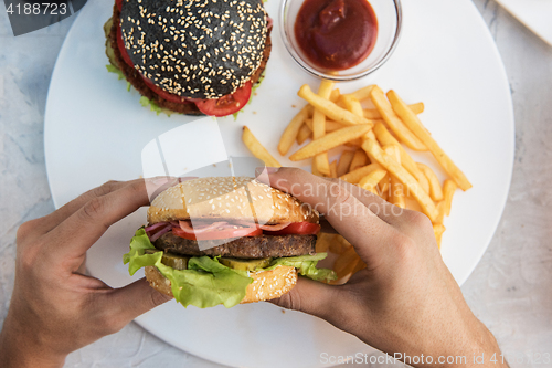 Image of Man eating burgers