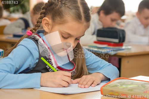 Image of First grader in class writing in notebook