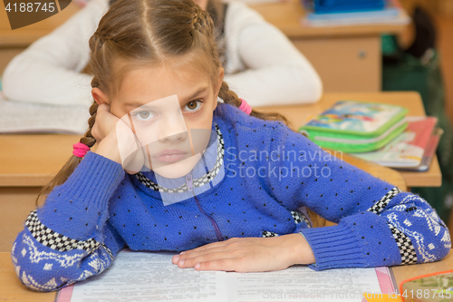 Image of First grader to read the lesson and looking at teacher listens carefully to his