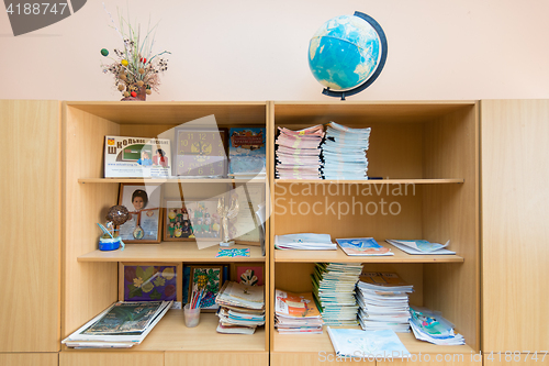 Image of Cabinet with open shelves in the classroom, a variety of school subjects lie on shelves
