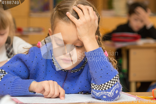 Image of First-grader at a lesson reads the text, running his finger along the lines