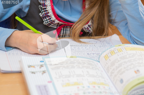 Image of A pupil in class writing in a notebook, close-up