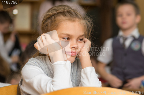 Image of Girl bored at school sitting at a desk on the reverse