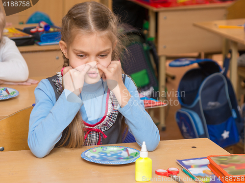 Image of The girl at a lesson at school stuck his fingers in the nostrils of the nose