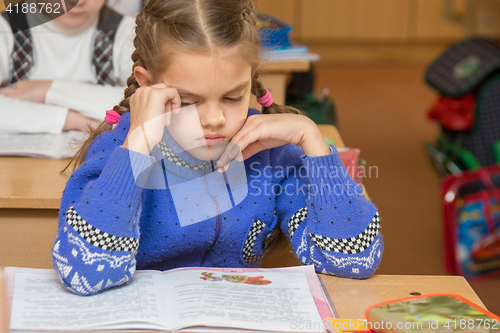 Image of First grader girl feels bad in the classroom at school