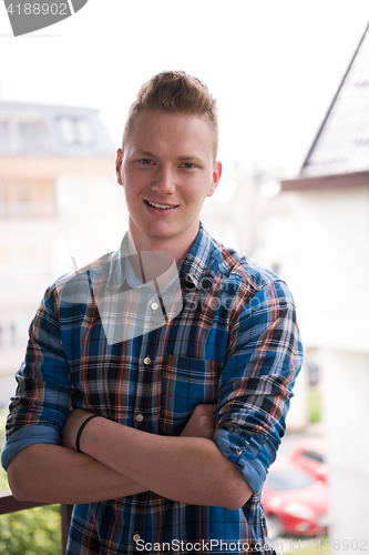 Image of man standing at balcony