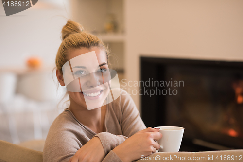 Image of woman with a mug near a fireplace