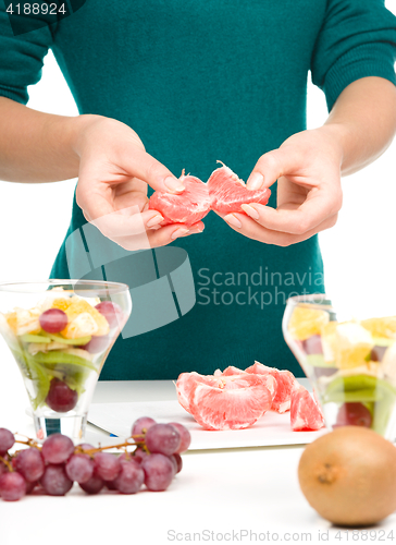 Image of Cook is peeling grapefruit for fruit dessert