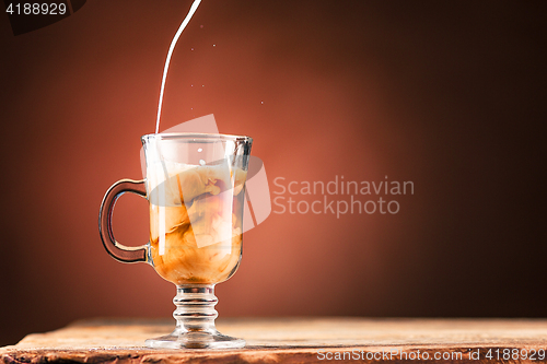 Image of Adding milk to a cup of coffee.