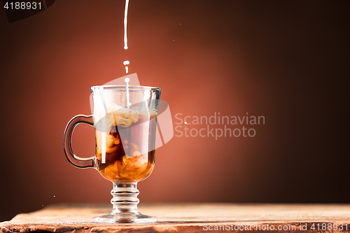 Image of Adding milk to a cup of coffee.