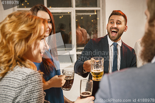 Image of Group of friends enjoying evening drinks with beer