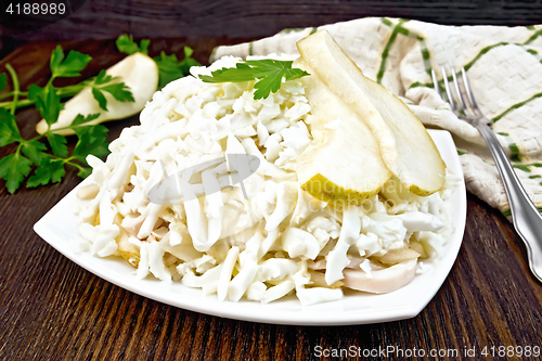 Image of Salad of squid and pears with fork on board